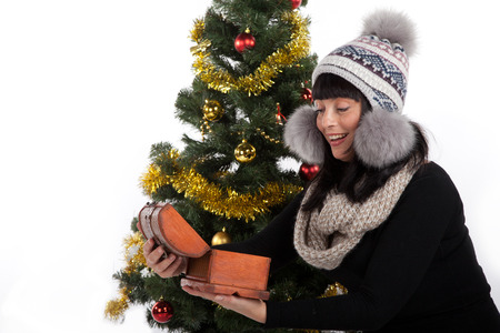 beautiful brunette woman looking at the Christmas tree giftsの写真素材