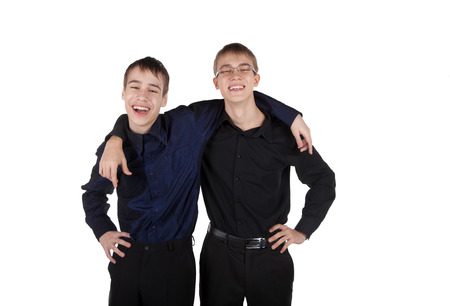 Two teenagers on a white background laughing embracingの写真素材