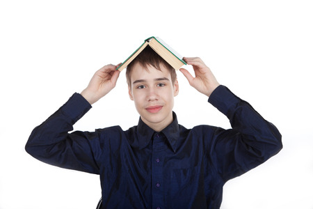 teenager with a book on his head in the studio on a white backgroundの写真素材