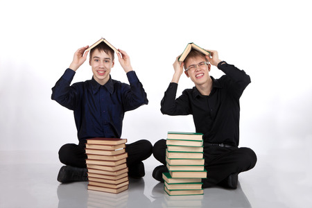Two teenagers with books on her headの写真素材