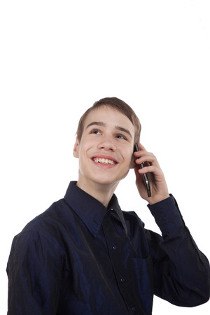 teenage boy having fun talking on the phone on white backgroundの写真素材