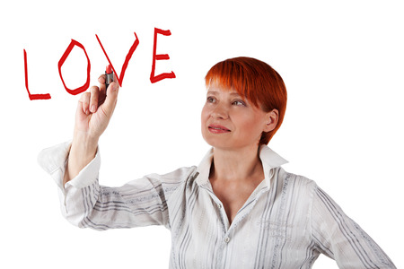 smiling woman draws a red lipstick on white backgroundの写真素材