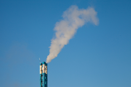Smoke from a pipe on a background of blue skyの写真素材