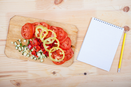 a sheet of paper and cut vegetables on the tableの写真素材
