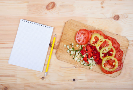 a sheet of paper and cut vegetables on the tableの写真素材