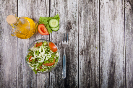 ?alad, fork and vegetable oil stand on a wooden tableの写真素材