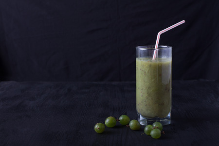 smoothies from gooseberry in a glass of styot on a black tableの写真素材