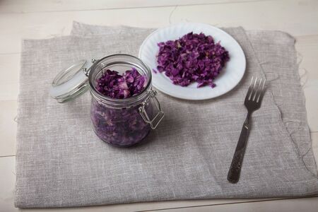 fermented white cabbage in glass jars on a  wooden tableの写真素材