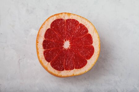 Ripe red sliced grapefruit on a light background. Healthy eating concept. Vitamins Trace elements. Flat layの写真素材