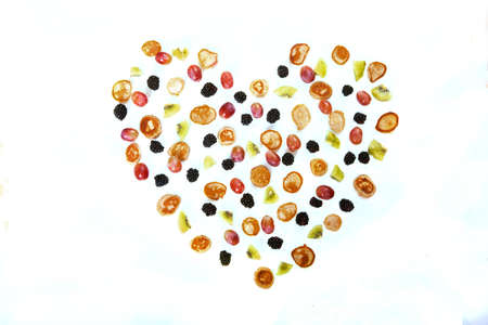 Heart pattern made from minipancakes, grapes and kiwi on a white background. Dessertの写真素材