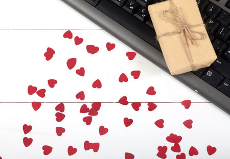 Computer keyboard, gift and hearts on a white background. Ordering gifts online. Online shopping.の写真素材