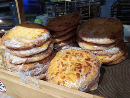 Freshly baked pizza in a plastic bag lies on a shelf in a bakery. Mobile photo.の写真素材
