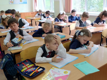 Pupils, schoolchildren, girls and boys study at their desks in the classroom. 04/22/2021のeditorial素材