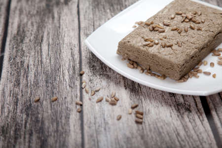 Halva in briquettes and in large pieces lies on a metal plate on a white background.の写真素材