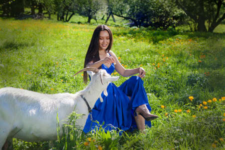 Beautiful woman with a goat in the Altai mountains. Tourism concept.の写真素材