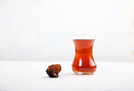 Chaga tea in a Turkish glass on a light background. Healthy food concept. copy space.の写真素材