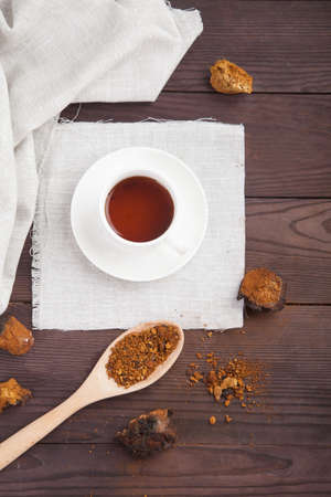 Chaga coffee in a white porcelain cup and a linen napkin on a brown wooden background. verticalの写真素材