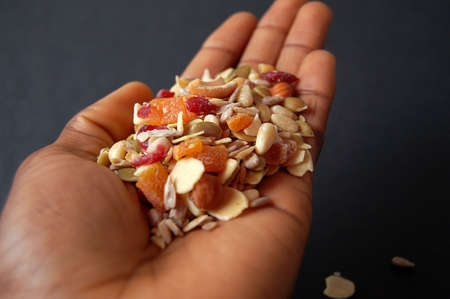 This is an image of a hand holding some country mix cerealの写真素材