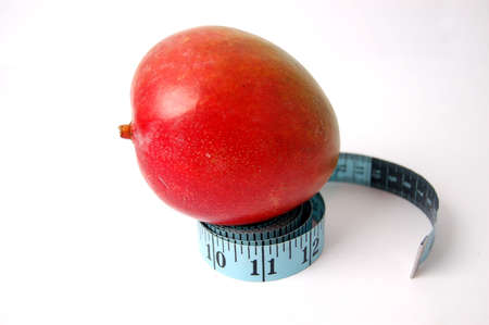 This is an image of a mango with a measuring tape.の写真素材