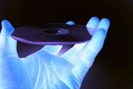 This is an image of a hand hold a data cd in a (dark technology room) lab like environment
の写真素材