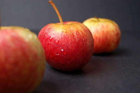 This is an image of three wet apples, nicely compositioned.の写真素材
