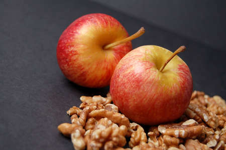 This is an image of two apples and some walnuts.の写真素材