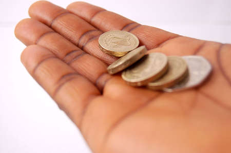 This is an image of a hand with pound coins on it.の写真素材