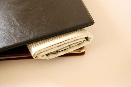 This is an image of a pair of portfolios with a newspaper in between them.の写真素材