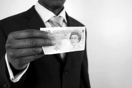 This is an image of a man holding 10 pound note.の写真素材