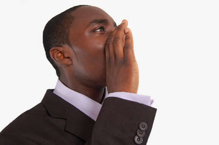 This is an image of business man with his hands near his lips making an annoucement.の写真素材