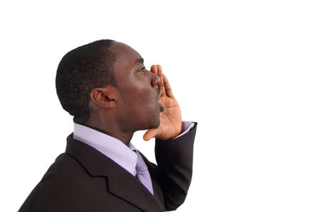 This is an image of business man with his hands near his lips making an annoucement.の写真素材
