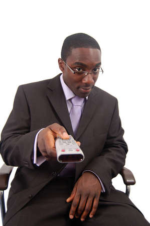 This is an image of a man holding a remote control, aiming to change the channel.の写真素材