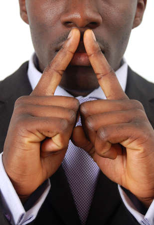 This is an image of businessman with his hands on his lips. This posture implies secrecy, illegal business, trust etc..の写真素材