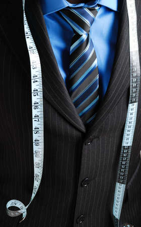 This is an image of business man wearing a tape measure across his suit.の写真素材