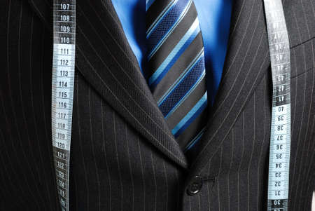 This is an image of business man wearing a tape measure across his suit.の写真素材