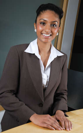 This is an image of a business woman smiling confidently at a reception desk.の写真素材