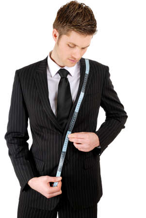 This is an image of a business man using a measuring tape.の写真素材
