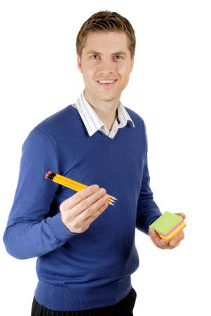 This is an image of business man holding a pack of pencils about to write on a pack of post its.の写真素材