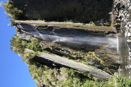 South Island New Zealand: Waterfall at the edge of the moraine field of Franz Josef Glacier