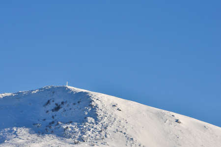 Frozen cross on Tarnica mountain in winter, Bieszczady, Poland.