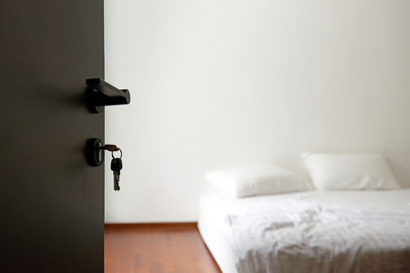 Opened door to modern white and clean bedroom interiorの写真素材