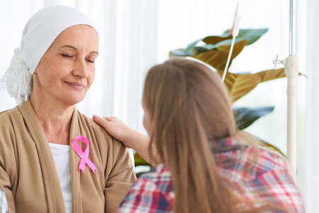 White caucasian female hairless and eyebrowless feel bad are praying and waiting for chemotherapy  in hospital room, breast cancer awareness month concept.の写真素材