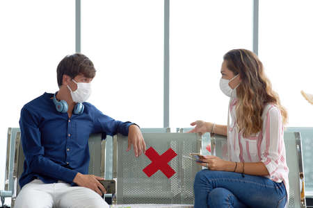 New normal white caucasian couple male - female traveller after corona virus, covid-19 outbreak, Social distancing at international  airport terminalの写真素材