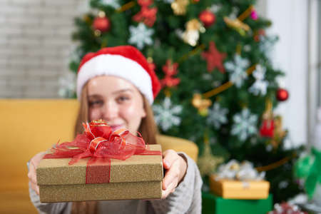 Merry christmas and Happy new year holiday, white woman caucasian celebrate, exchanging gifts relax in front of a yellow sofa and christmas tree.の写真素材