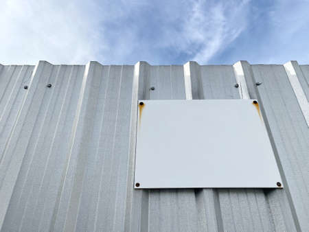 Blank rustic plate metal signs for advertising or artwork with white space patina on metal sheet fender on blue sky.の写真素材