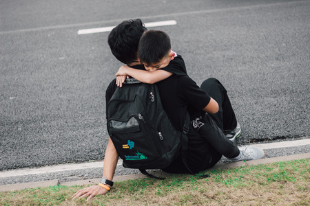 sad son hugging his dad on the streetの写真素材