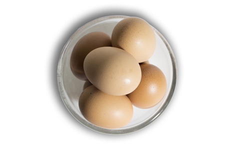 Brown eggs in transparent bowl isolated on white backgroundの写真素材