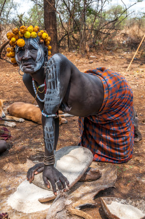 Omo Valley people - Mursi woman grinding sorghumのeditorial素材