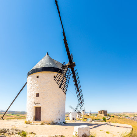 CONSUEGRA,SPAIN - MAY 26,2022 - View at the Windmills of Consuegra, with the Castle of La Muela in the background. These windmills became famous in the 17th century, when Don Quixote.のeditorial素材