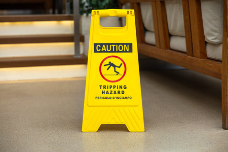 Yellow Caution Tripping Hazard Sign Near Staircase Indoor Safety Prevention Conceptの写真素材